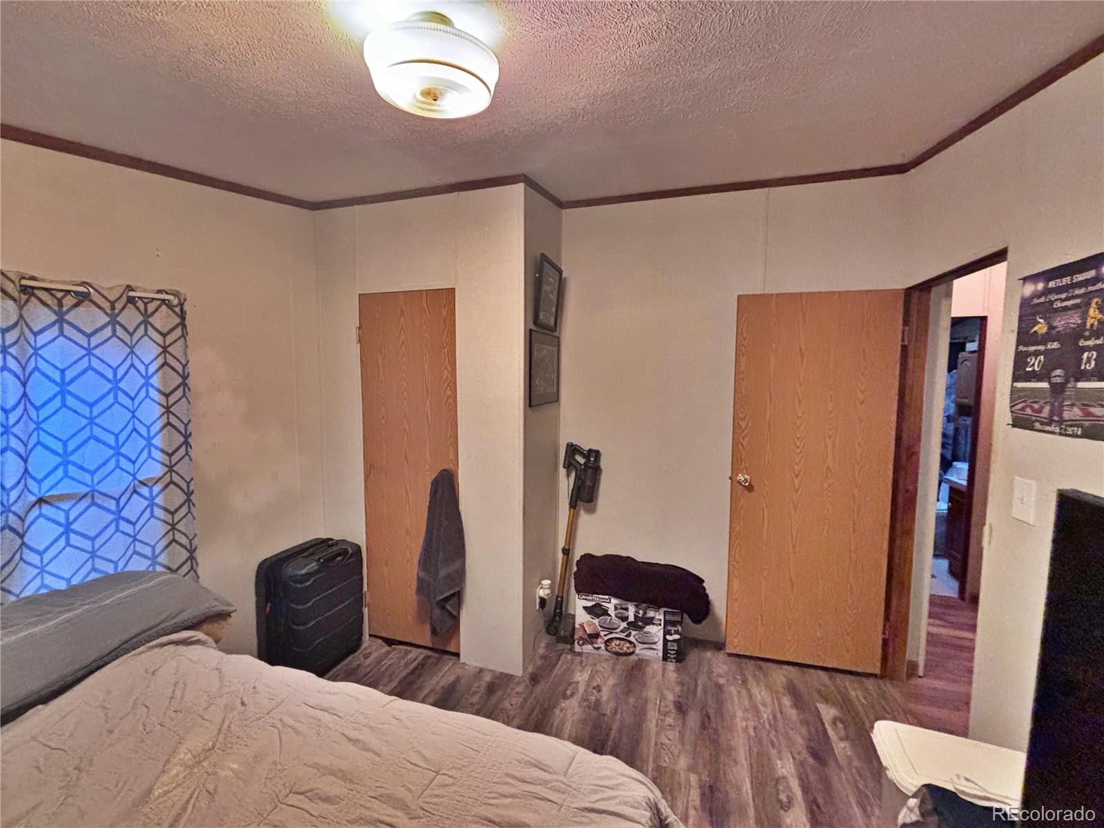 201 Pinto Street Golden, CO 80401 - Photo 6 of 22 a bedroom with a bed and a flat tv screen on the dresser