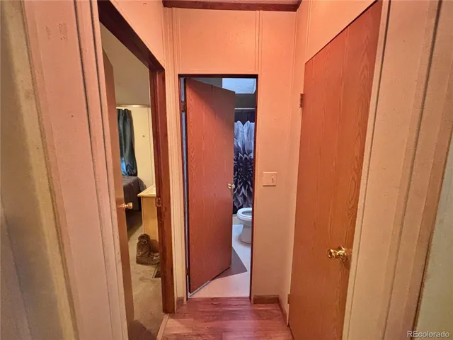 a view of a hallway with wooden floor and entryway