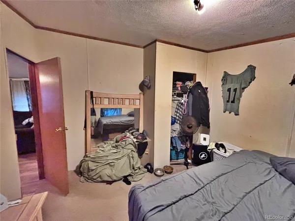 a bedroom with bed and a mirror