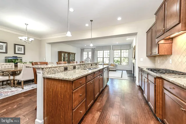 a kitchen with granite countertop a sink stove and wooden cabinets