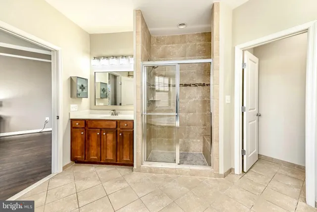 a spacious bathroom with a shower sink and mirror
