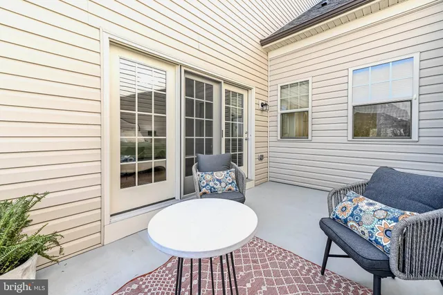 a view of a patio with couple of chairs and a potted plant