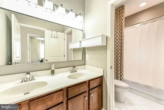 a bathroom with a sink toilet a mirror and shower