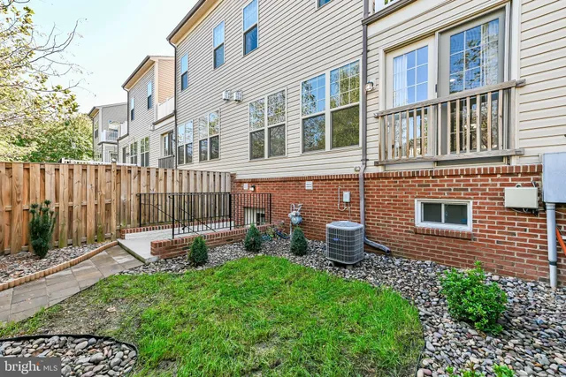 a brick house with a small yard and wooden fence