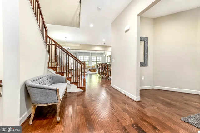 a hallway with wooden floor stairs and furniture