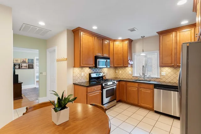a kitchen with stainless steel appliances granite countertop sink stove and refrigerator