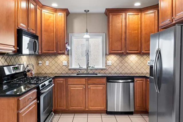 a kitchen with stainless steel appliances granite countertop a stove a refrigerator and a sink