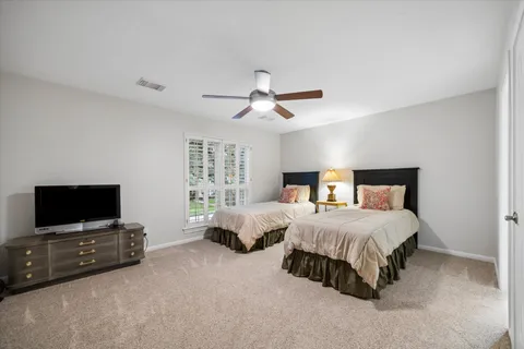 a bedroom with bed tv and a window