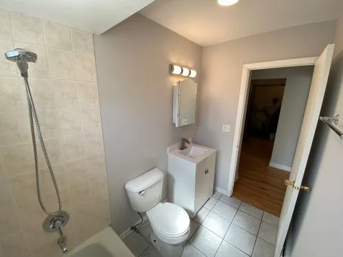 a white toilet sitting next to a bathroom sink and vanity