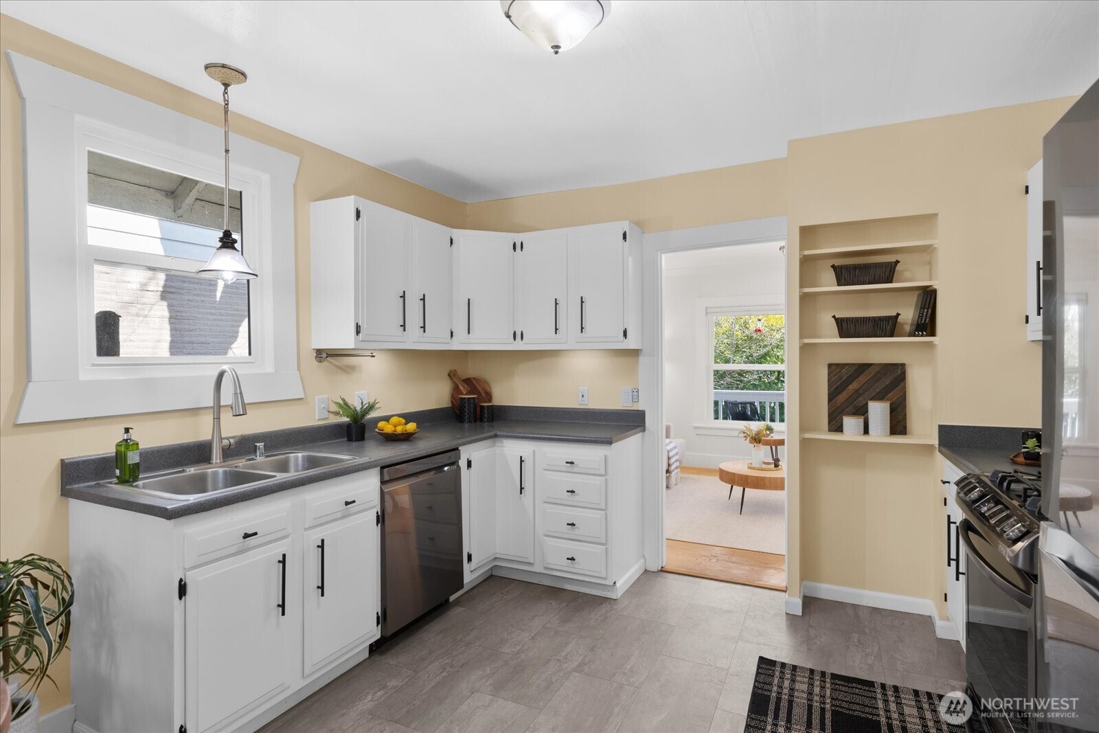 7729 18th Avenue Southwest Seattle, WA 98106 - Photo 17 of 36 a kitchen with stainless steel appliances granite countertop a sink stove and white cabinets
