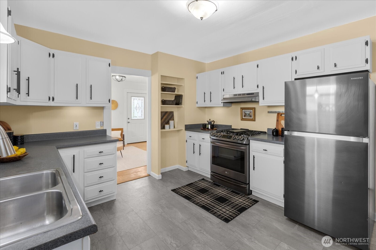 7729 18th Avenue Southwest Seattle, WA 98106 - Photo 18 of 36 a kitchen with white cabinets and white appliances
