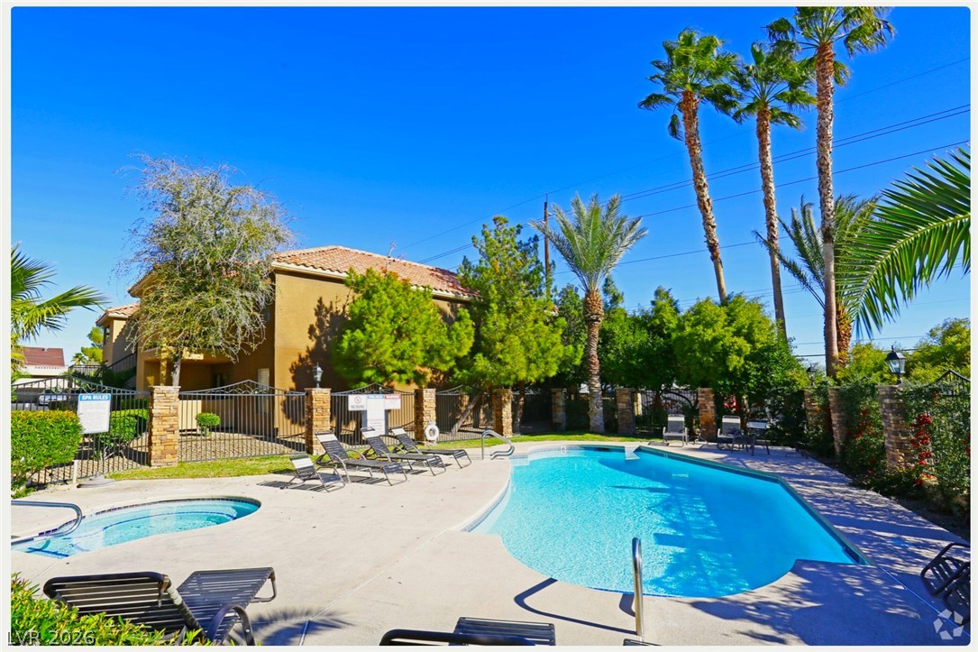 3135 South Mojave Road, Unit 156 Las Vegas, NV 89121 - Photo 13 of 18 An inviting swimming pool and spa beckon amidst a backdrop of lush palms and stucco architecture.