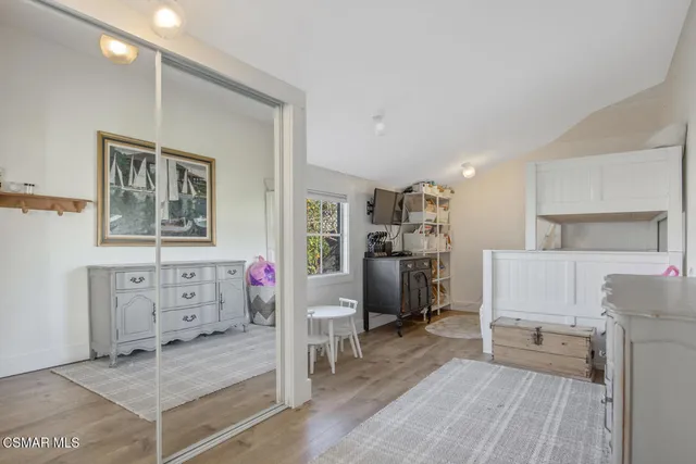 a view of a hallway with closet and wooden floor