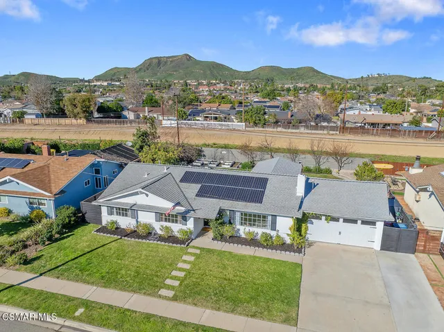 an aerial view of a house with swimming pool and mountains