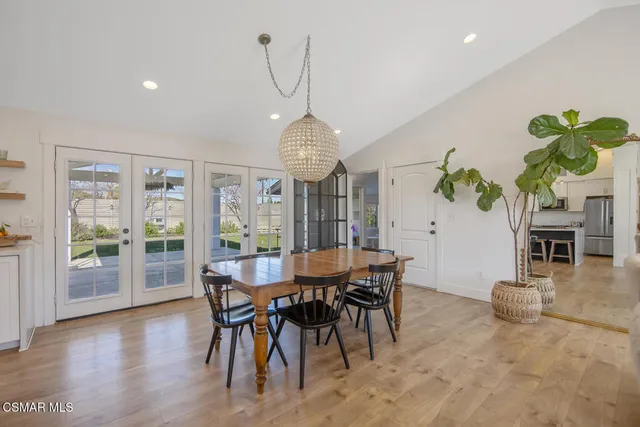 a kitchen with a table chairs microwave and refrigerator