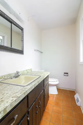 a bathroom with a granite countertop sink and a mirror