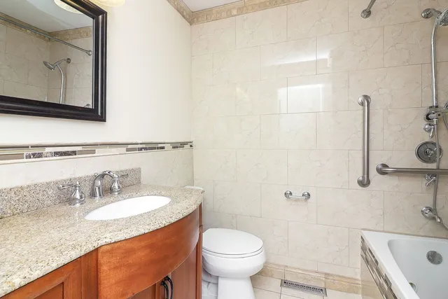 a bathroom with a granite countertop sink toilet and shower