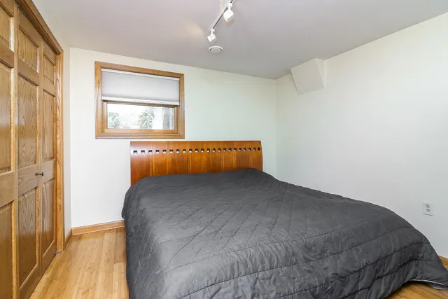 a bedroom with a bed and wooden floor