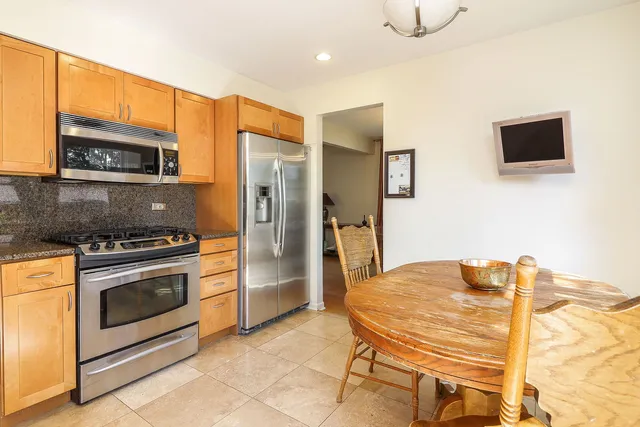 a kitchen with stainless steel appliances kitchen island a stove a sink and a microwave
