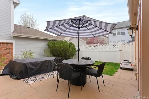 a view of a house with a backyard and furniture