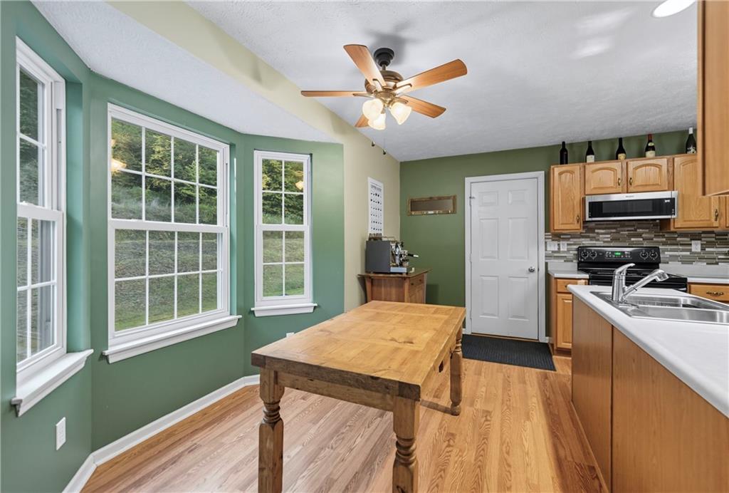 139 Ladybug Lane Ligonier, PA 15658 - Photo 13 of 33 a kitchen with a refrigerator a stove cabinets and living room view