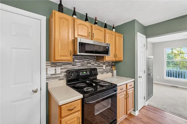 a kitchen with stainless steel appliances a stove a microwave a sink and cabinets
