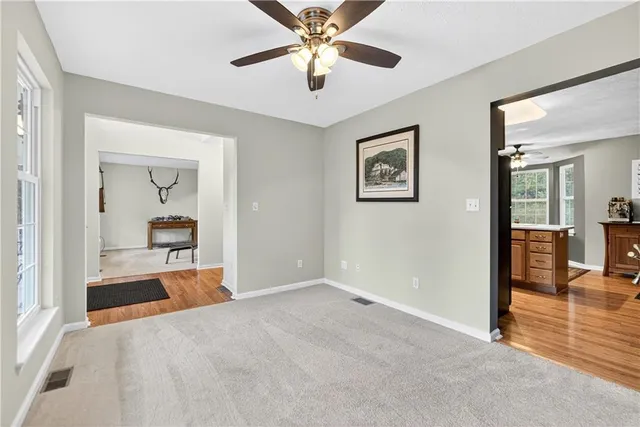 a view of a hallway with a livingroom and a chandelier fan