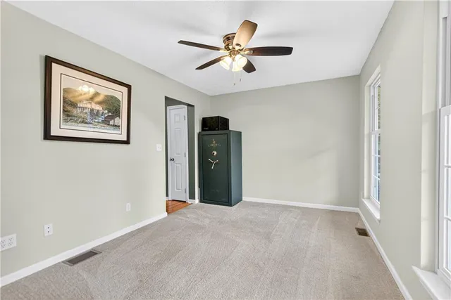 a view of a livingroom with a ceiling fan and window