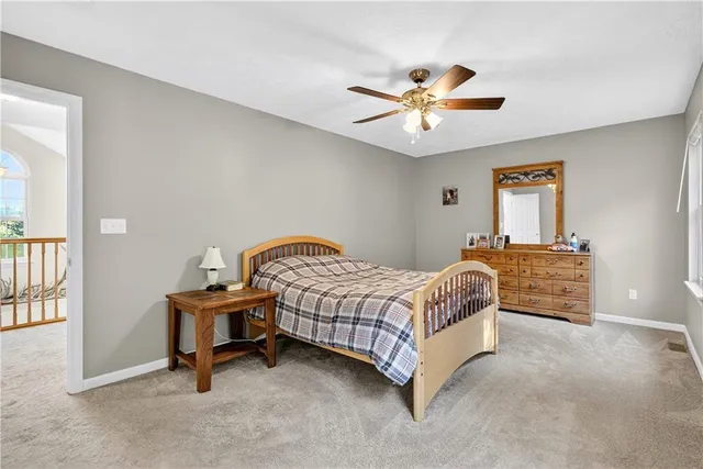 a bedroom with a bed and a ceiling fan