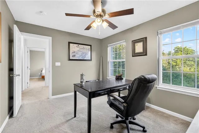 a view of a workspace with furniture and a window