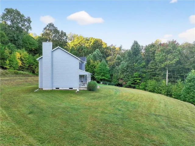 a backyard of a house with plants and large tree