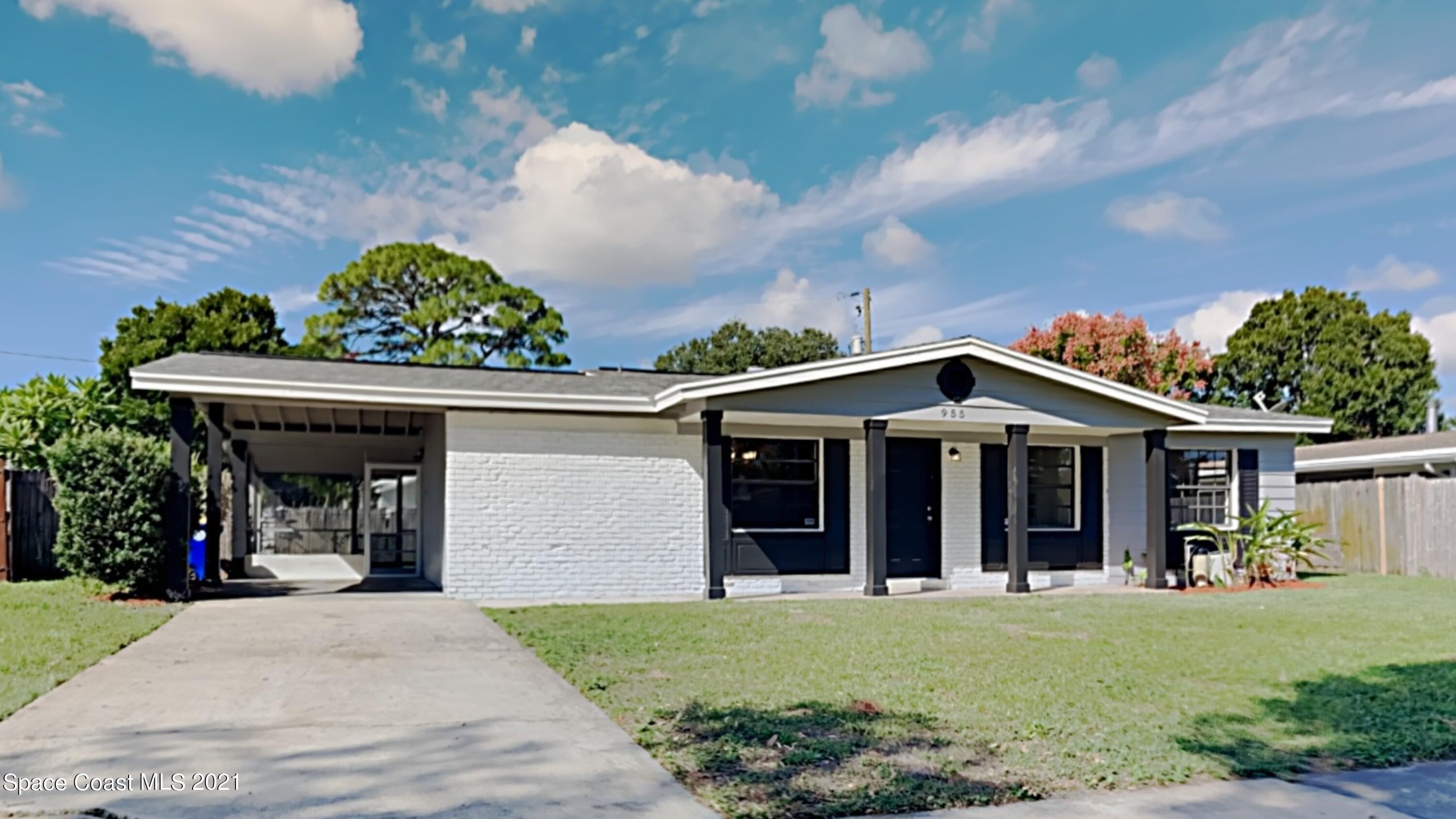 955 Lexington Road Rockledge, FL 32955 - Photo 1 of 18 a view of a front house with large windows and a yard