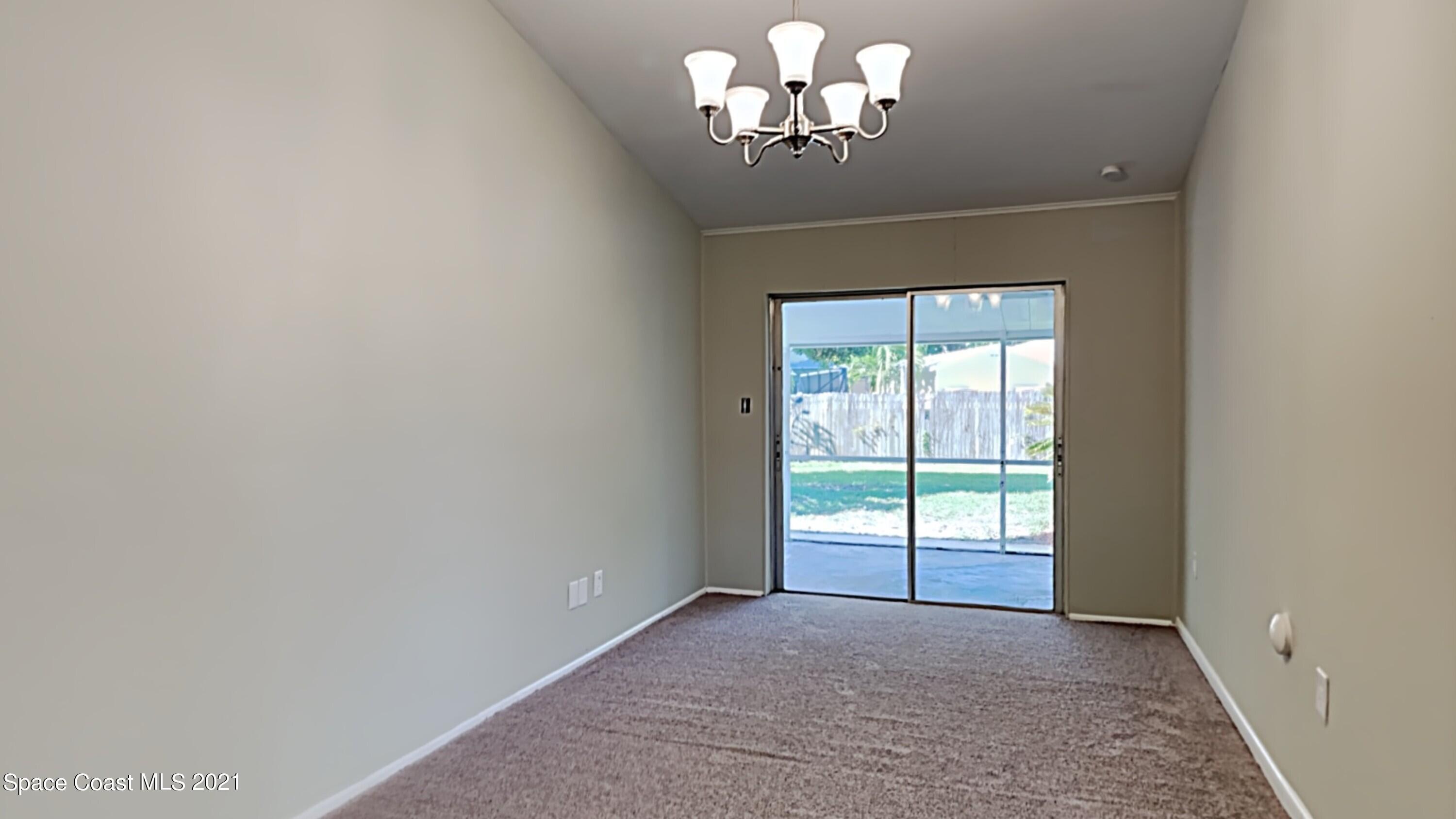 955 Lexington Road Rockledge, FL 32955 - Photo 5 of 18 a view of a livingroom with a chandelier fan and windows