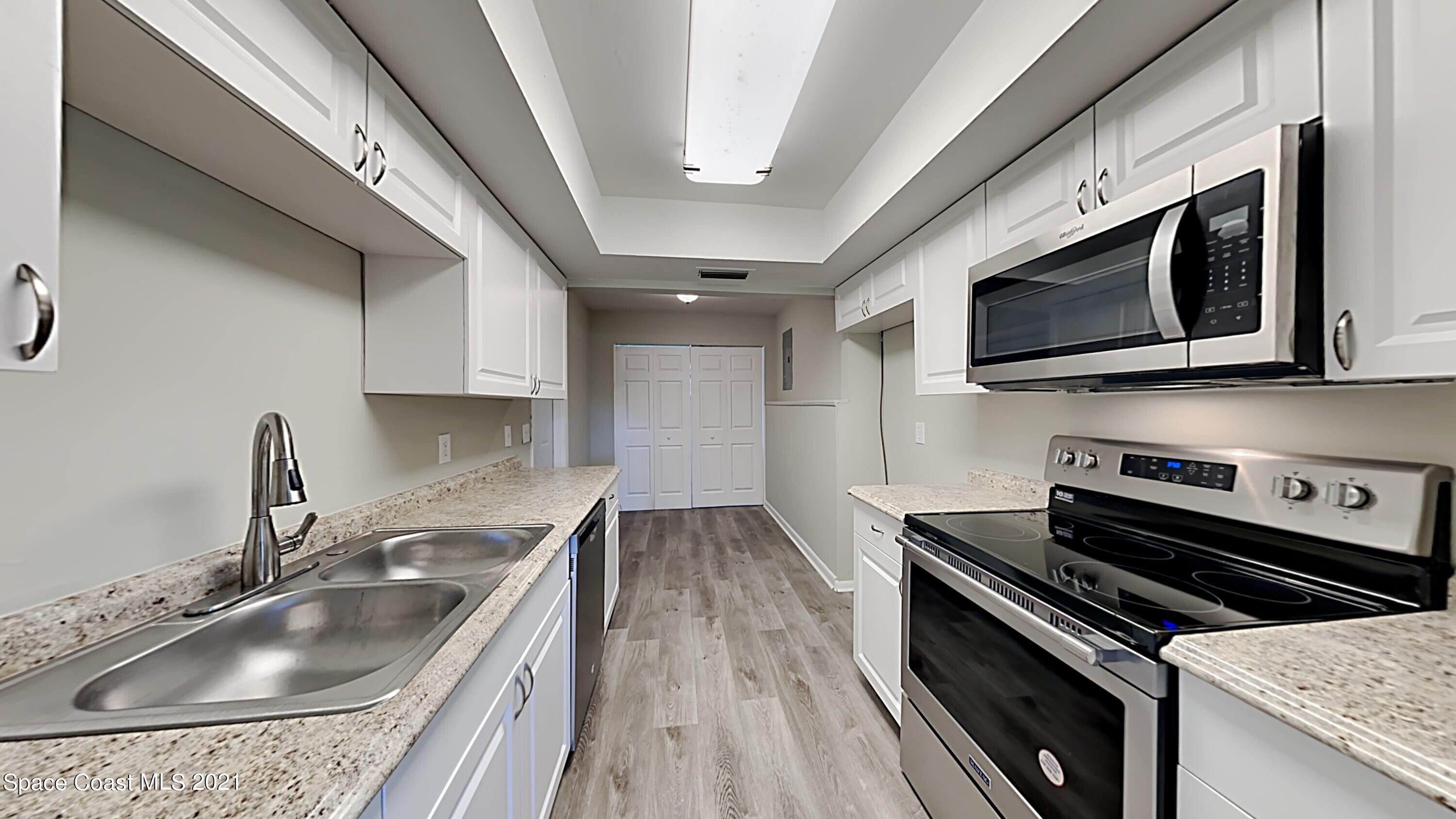 955 Lexington Road Rockledge, FL 32955 - Photo 6 of 18 a kitchen with stainless steel appliances granite countertop a sink and stove top oven