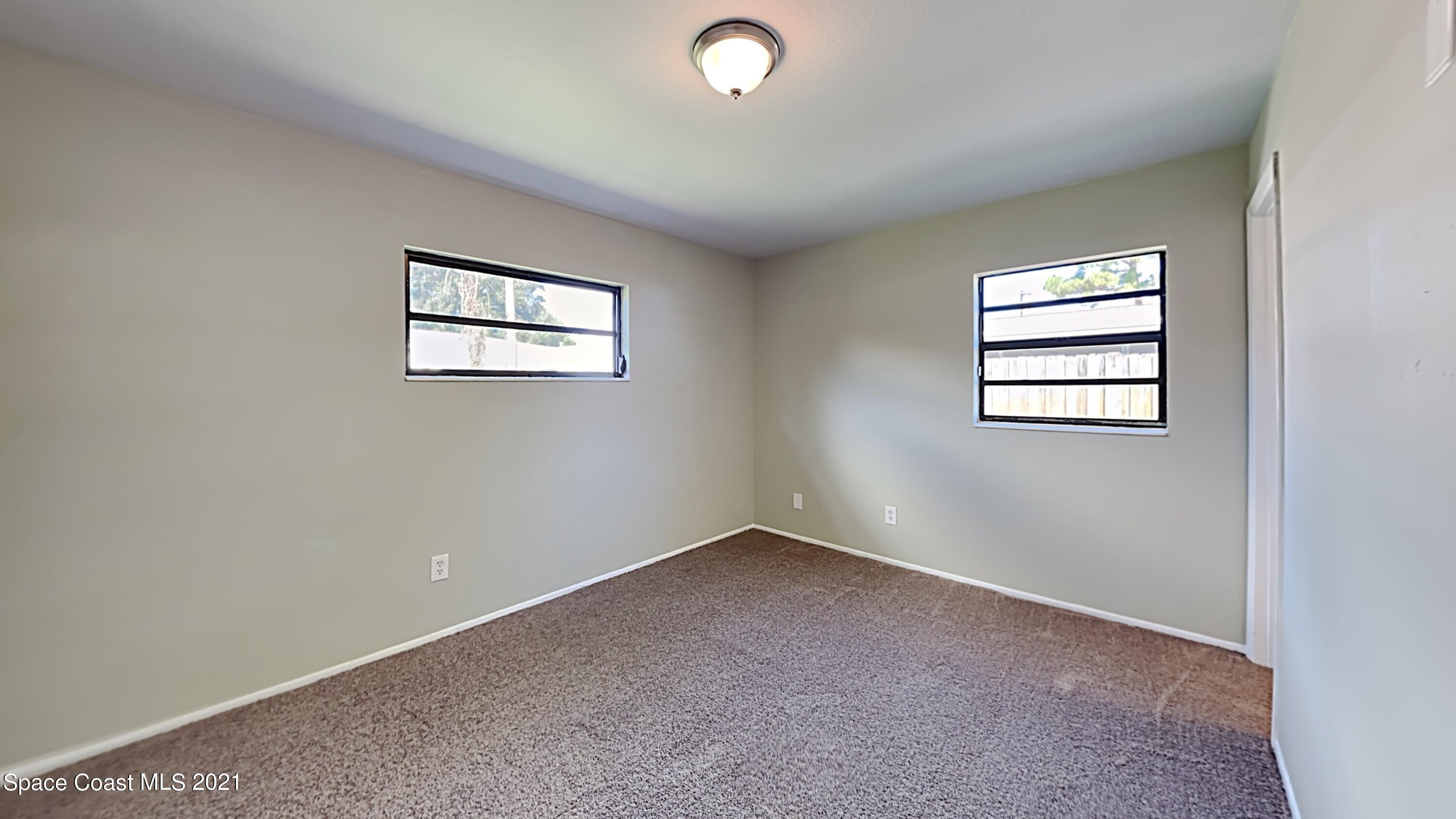 955 Lexington Road Rockledge, FL 32955 - Photo 8 of 18 an empty room with windows and closet