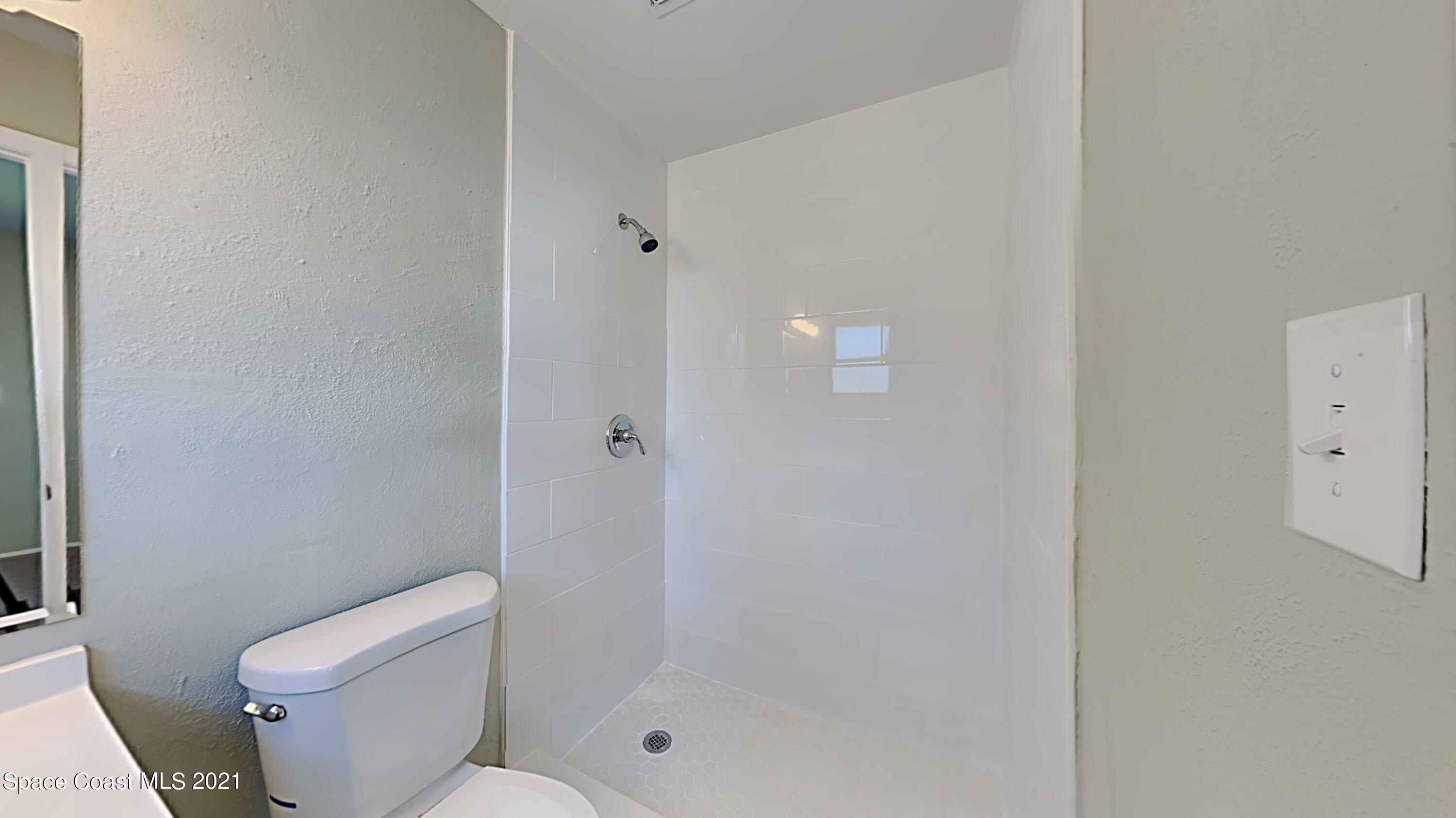 955 Lexington Road Rockledge, FL 32955 - Photo 10 of 18 a white toilet sitting next to a shower