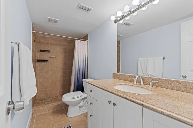 a bathroom with a sink vanity mirror and toilet