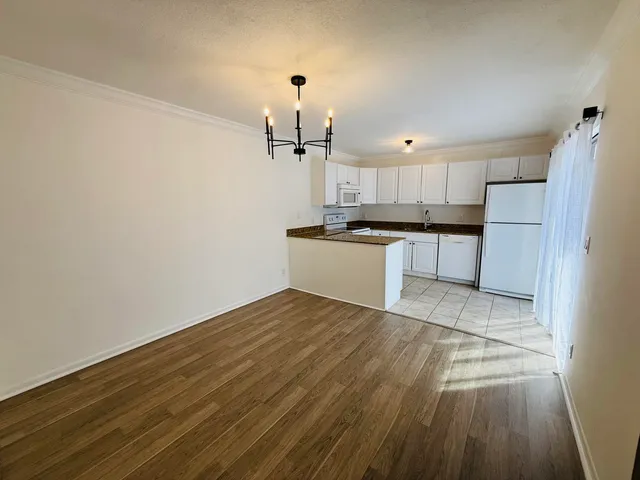 a kitchen with a sink a stove a refrigerator and white cabinets