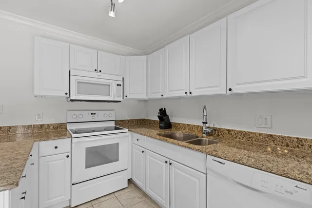a view of a hallway with a chandelier fan and windows