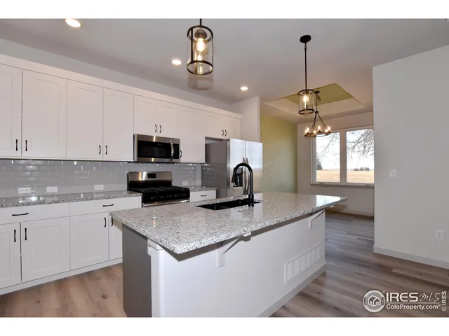 a kitchen with kitchen island granite countertop a sink stainless steel appliances and cabinets