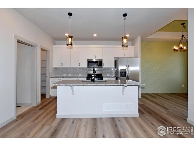 a open kitchen with kitchen island white cabinets and stainless steel appliances