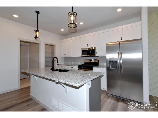 a kitchen with kitchen island white cabinets and stainless steel appliances