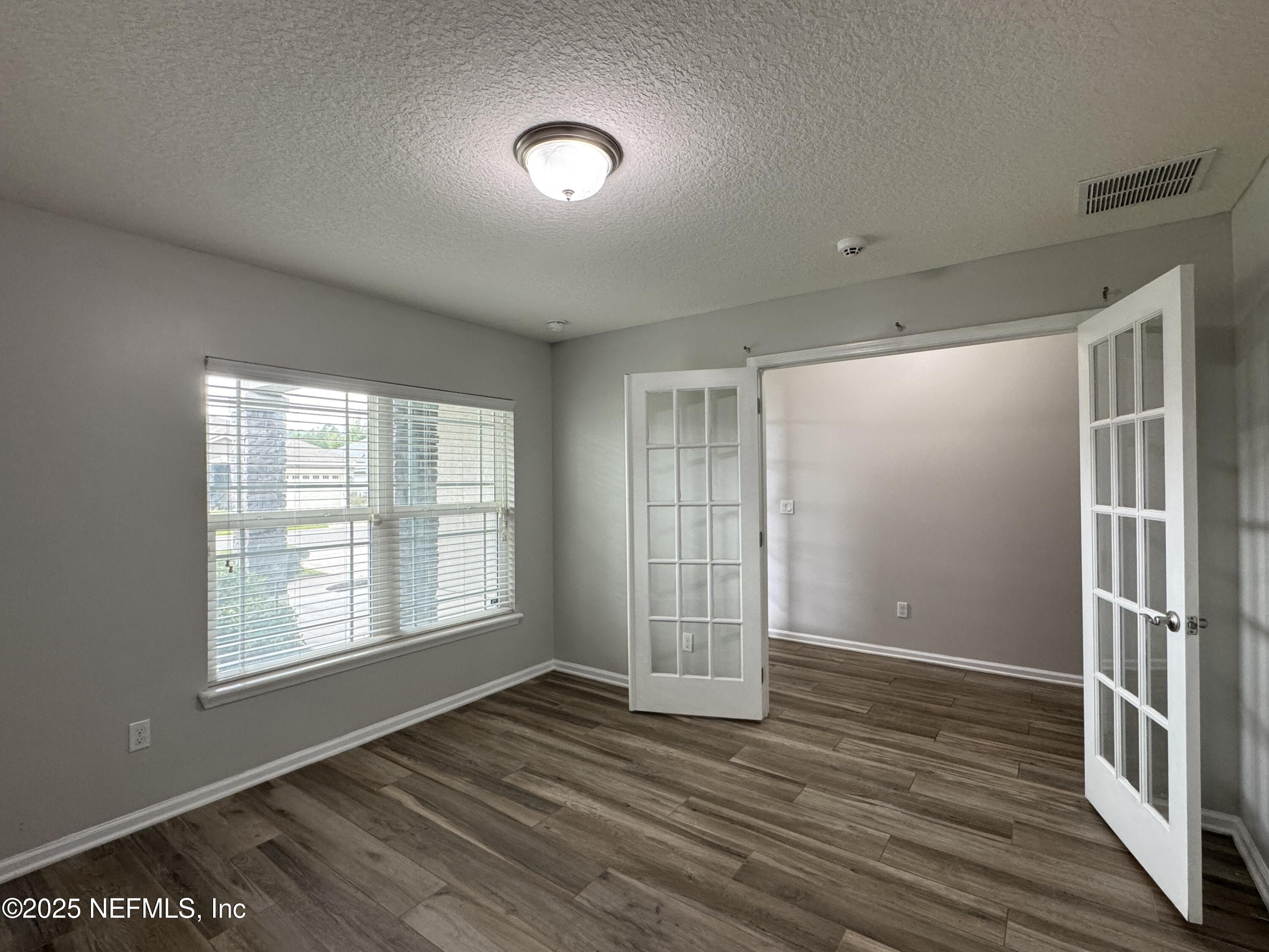 94267 Woodbrier Circle Fernandina Beach, FL 32034 - Photo 13 of 32 a view of an empty room with wooden floor and a window