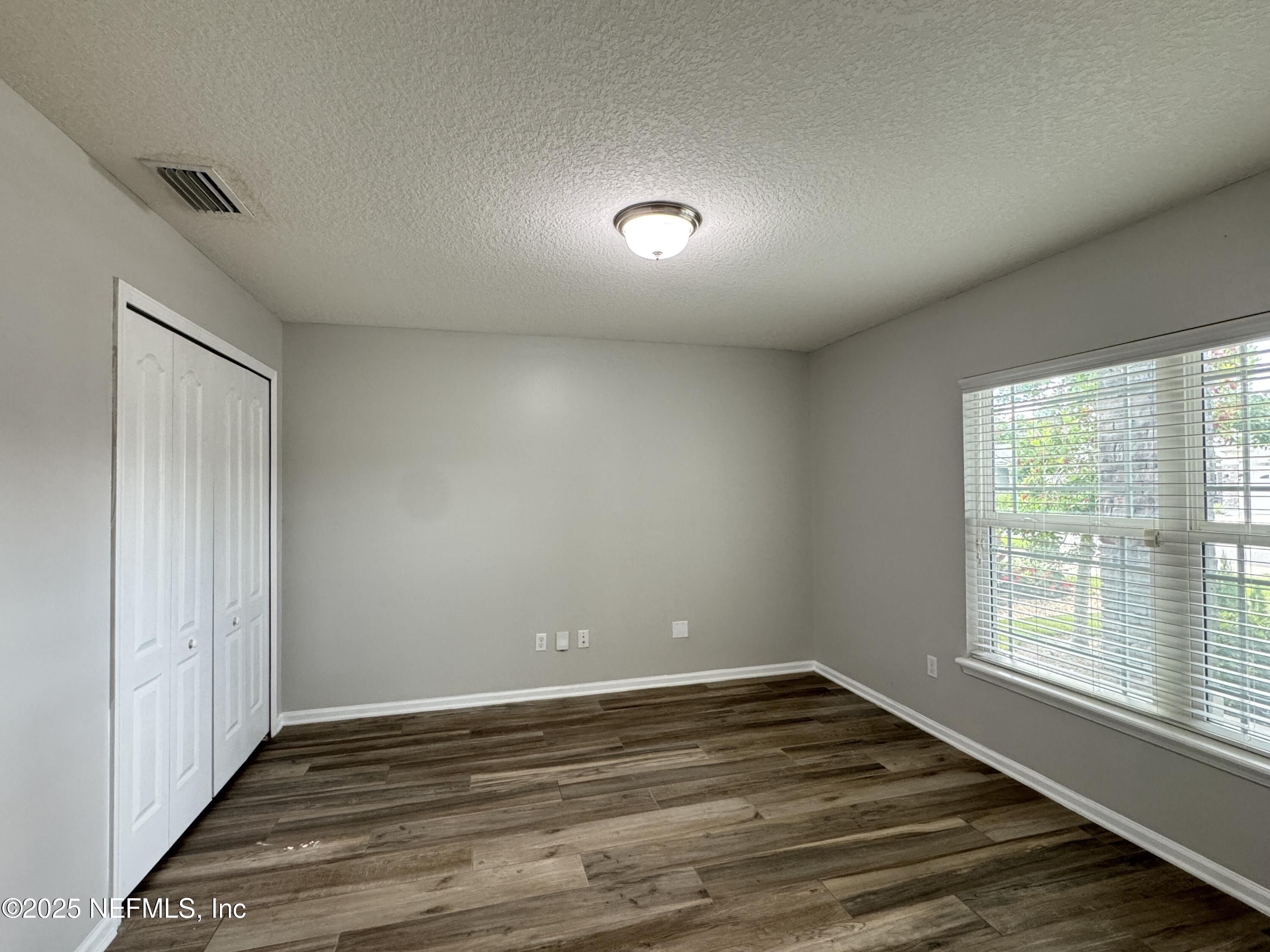 94267 Woodbrier Circle Fernandina Beach, FL 32034 - Photo 14 of 32 an empty room with wooden floor and windows