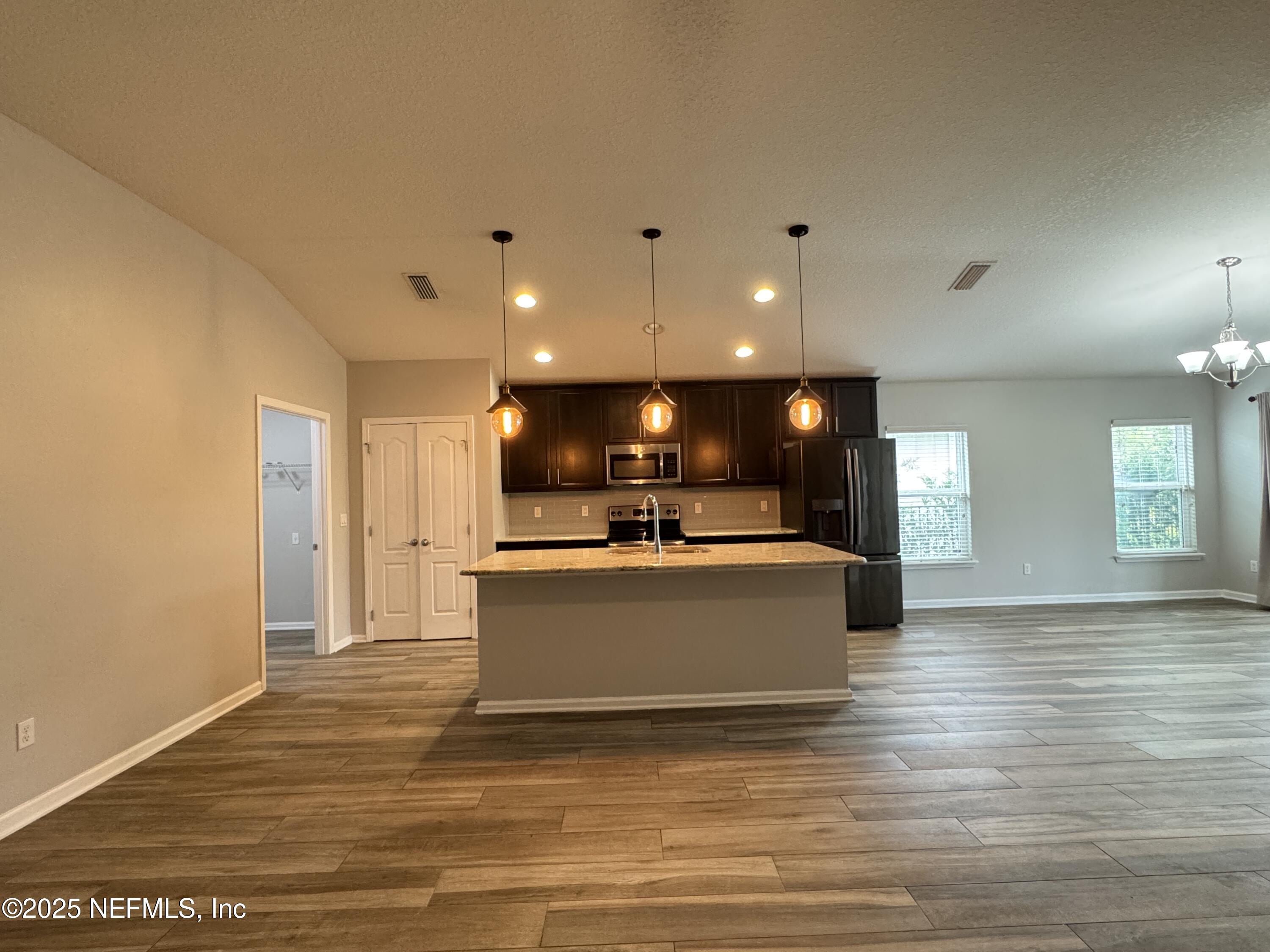 94267 Woodbrier Circle Fernandina Beach, FL 32034 - Photo 6 of 32 a view of kitchen with kitchen island a sink wooden floor and a refrigerator