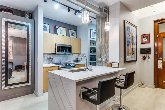 a open kitchen with stainless steel appliances granite countertop a sink dishwasher and a refrigerator with wooden floor