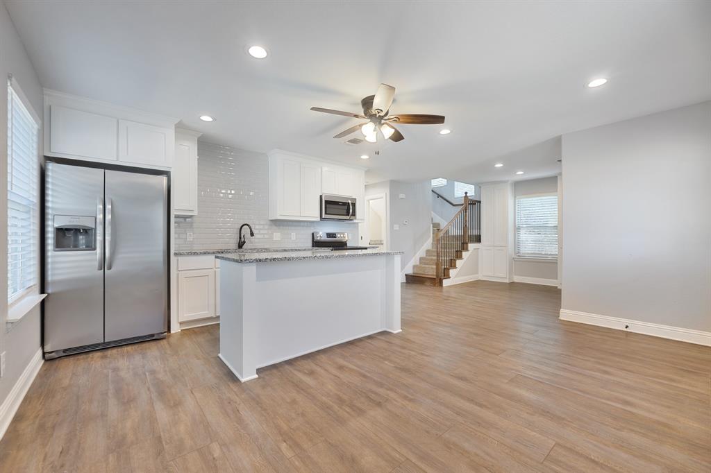 1713 Bronco Road Granbury, TX 76049 - Photo 7 of 23 Open-concept living space featuring wood-finish flooring, recessed lighting, and a neutral color palette