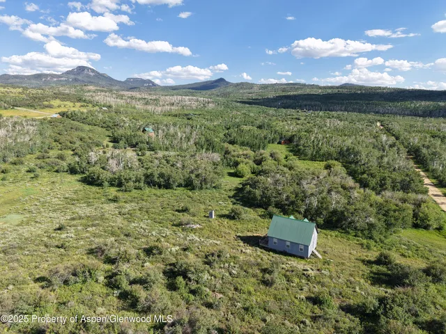 an aerial view of a houses with a yard