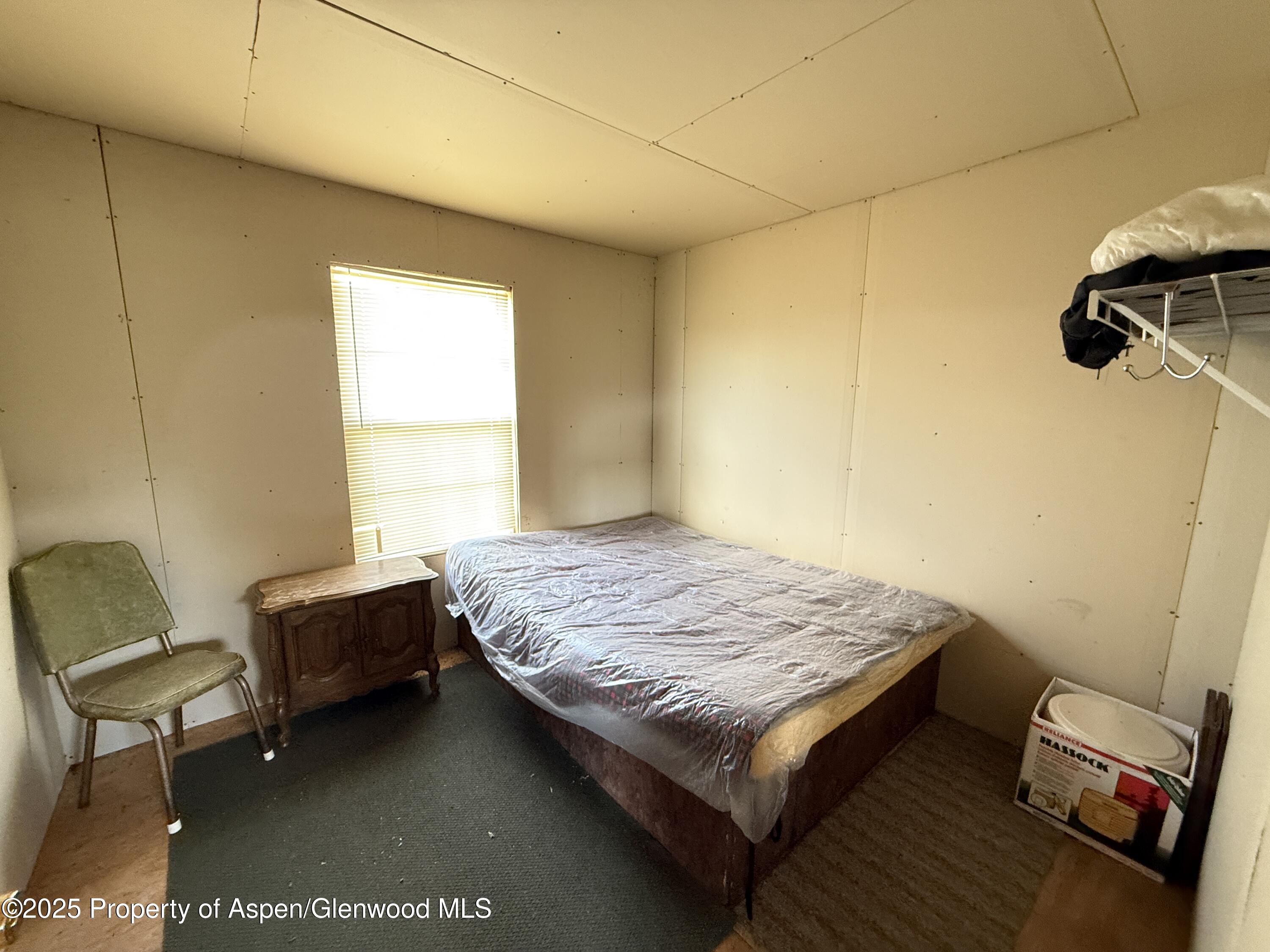 276 Sycamore Road, Unit LOT 288 Craig, CO 81625 - Photo 19 of 24 a bedroom with a bed and a chair
