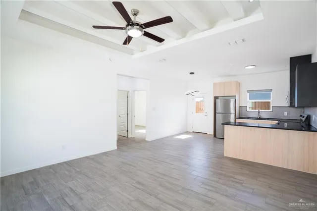 a view of a kitchen with a sink and wooden floor